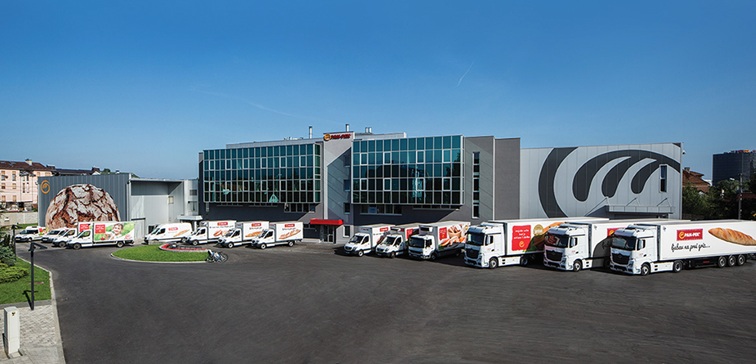 A large building with many trucks parked in front of it

AI-generated content may be incorrect.